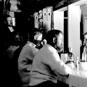 A group of people standing in front of a mirror posing for the camera.