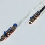 Two large boats saliing through sea ice