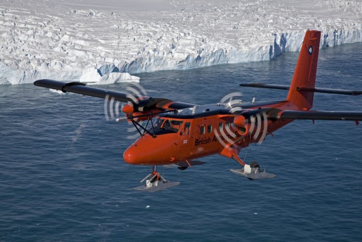 A plane flying over a body of water.