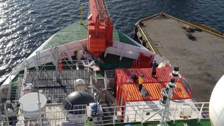 A boat is docked next to a body of water.