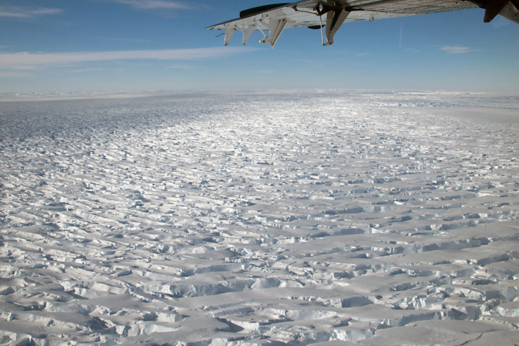 A plane flies over ice