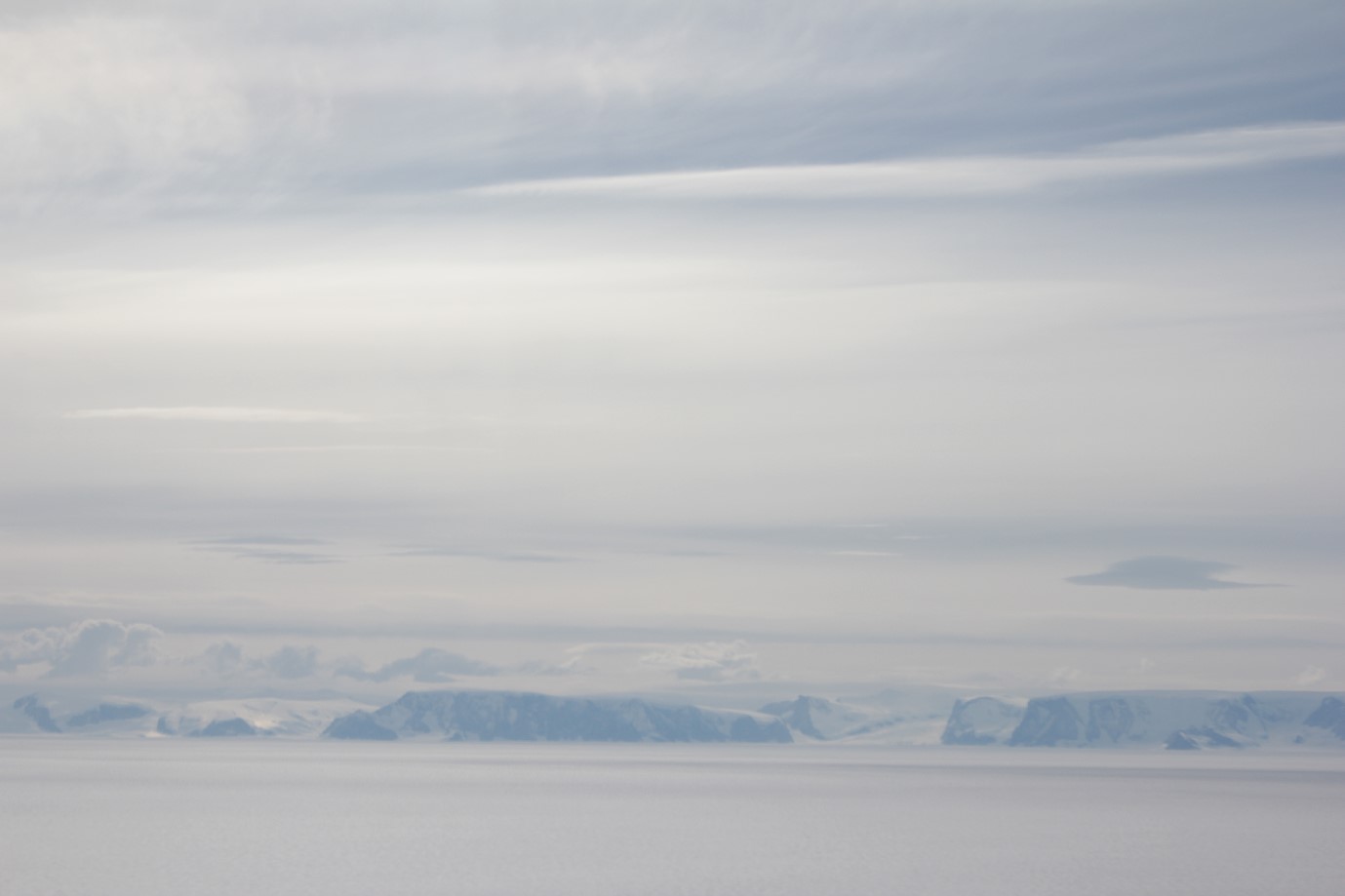 A group of clouds in the sky over a body of water.