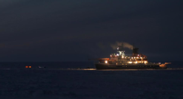 A large body of water with a reseach station in the night sky.