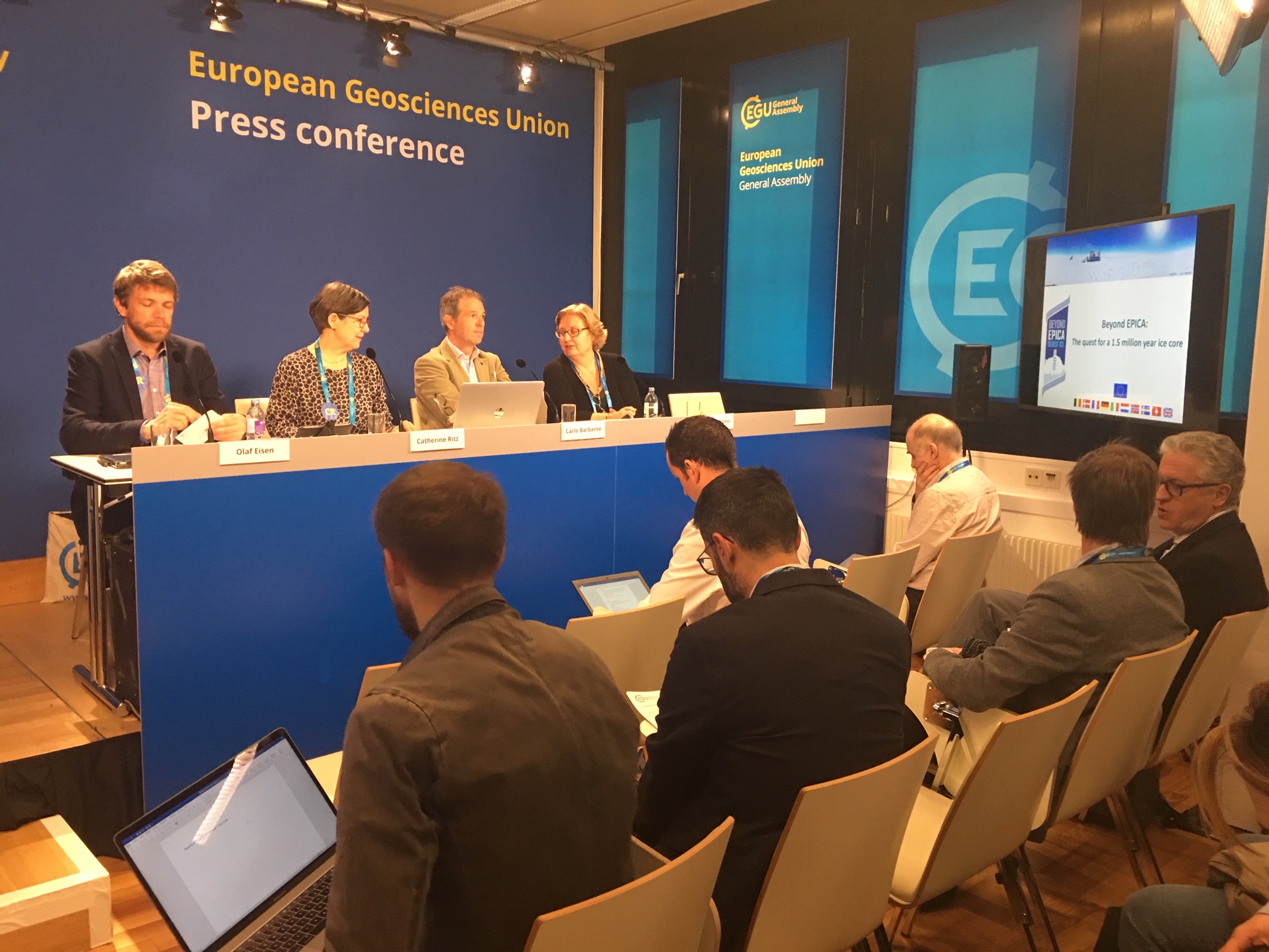 A group of people standing in front of a computer.