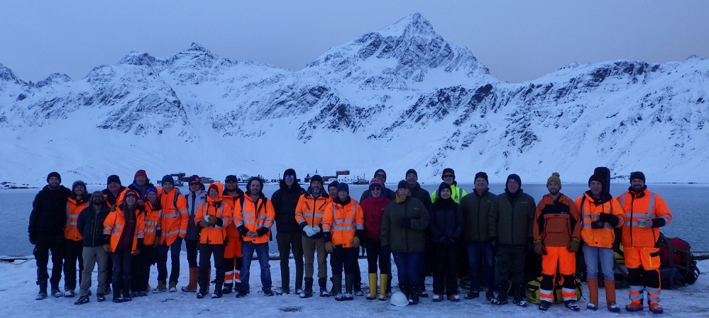 A group of people standing on top of a snow covered mountain.