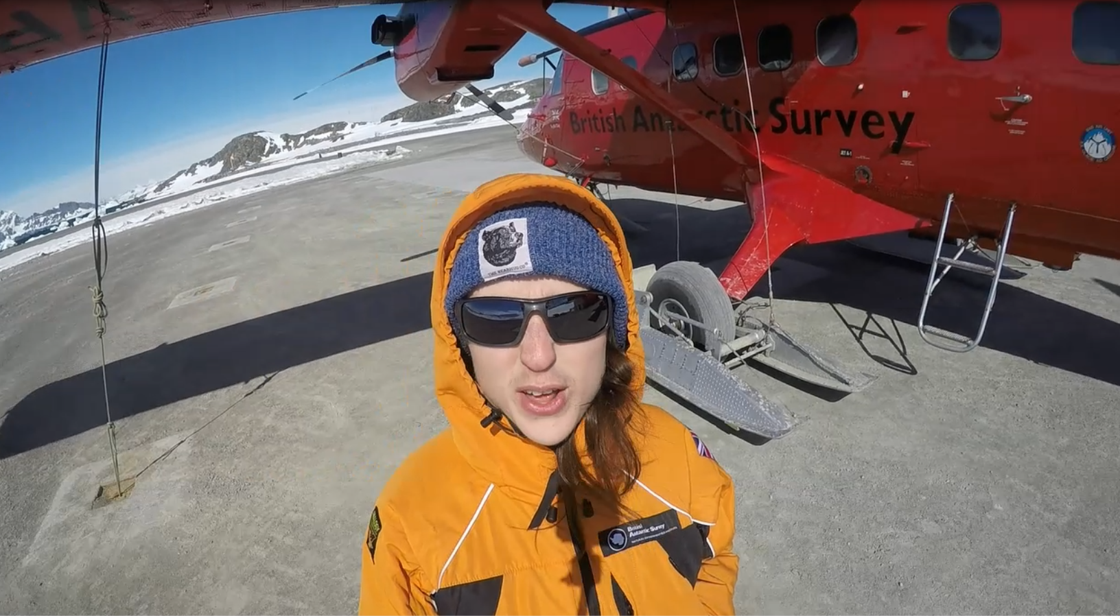 A person holding an orange umbrella.