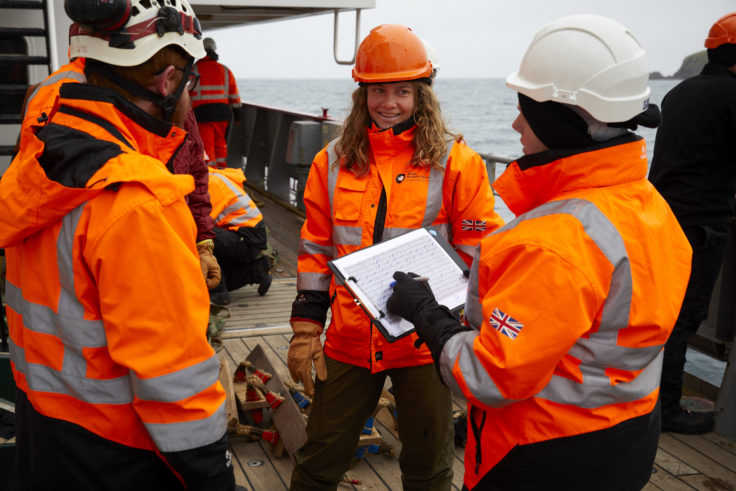 A group of people wearing high visibility gear and hard hats