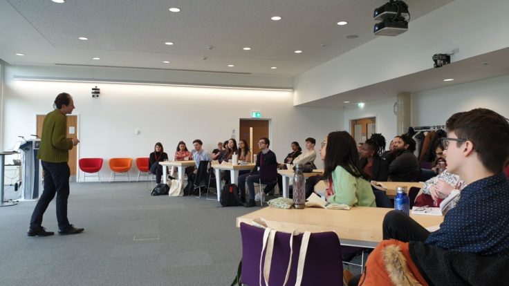 A group of students listening to a talk in a conference room