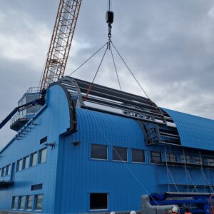 A large crane on the back of a large blue building
