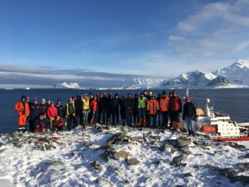 A group of people standing on top of a snow covered mountain