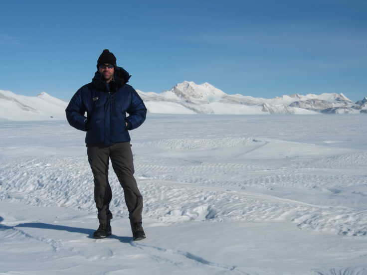 A man standing on top of a snow covered slope