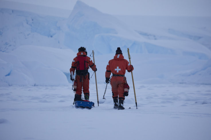 Two people cross country skiing in the snow