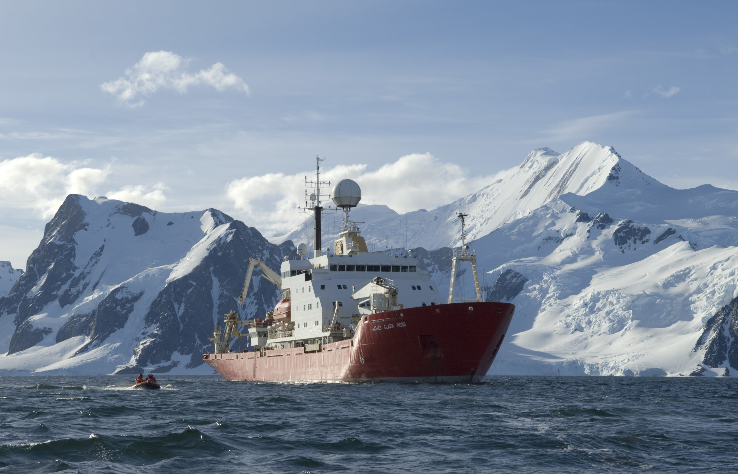 A large ship in the water with a mountain in the background