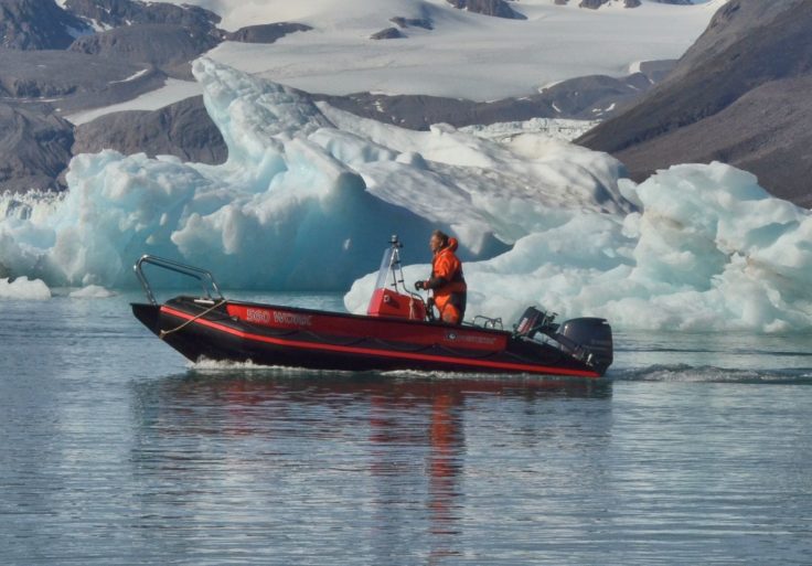 A boat on a body of water with a mountain in the background