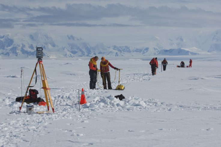 A group of people riding skis on top of a snow covered slope