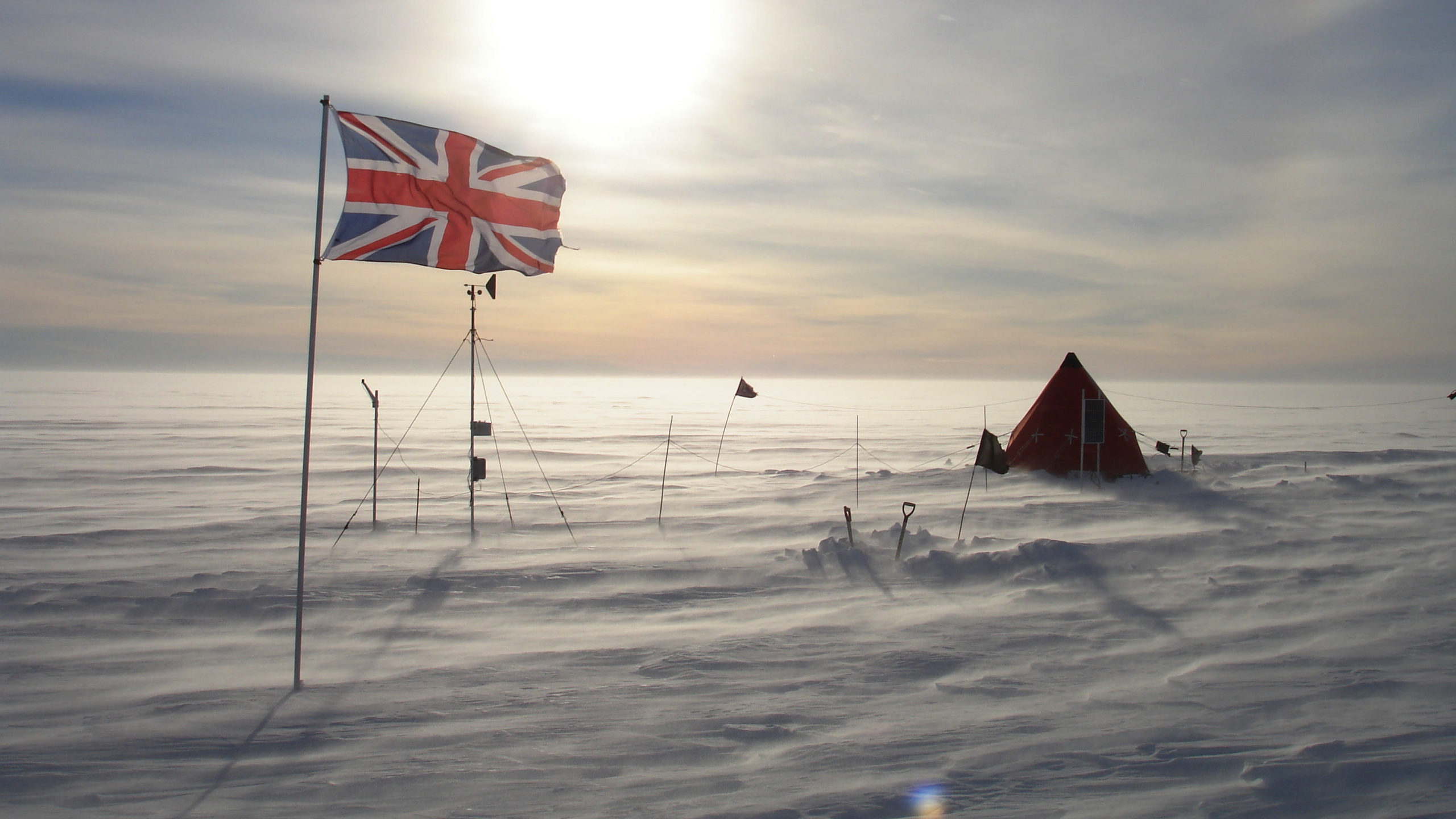 A British flag flies in front of a red pyramid tent on Thwaites Glacier