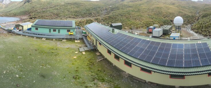 An array of solar panels on top of the roofs of two buildings