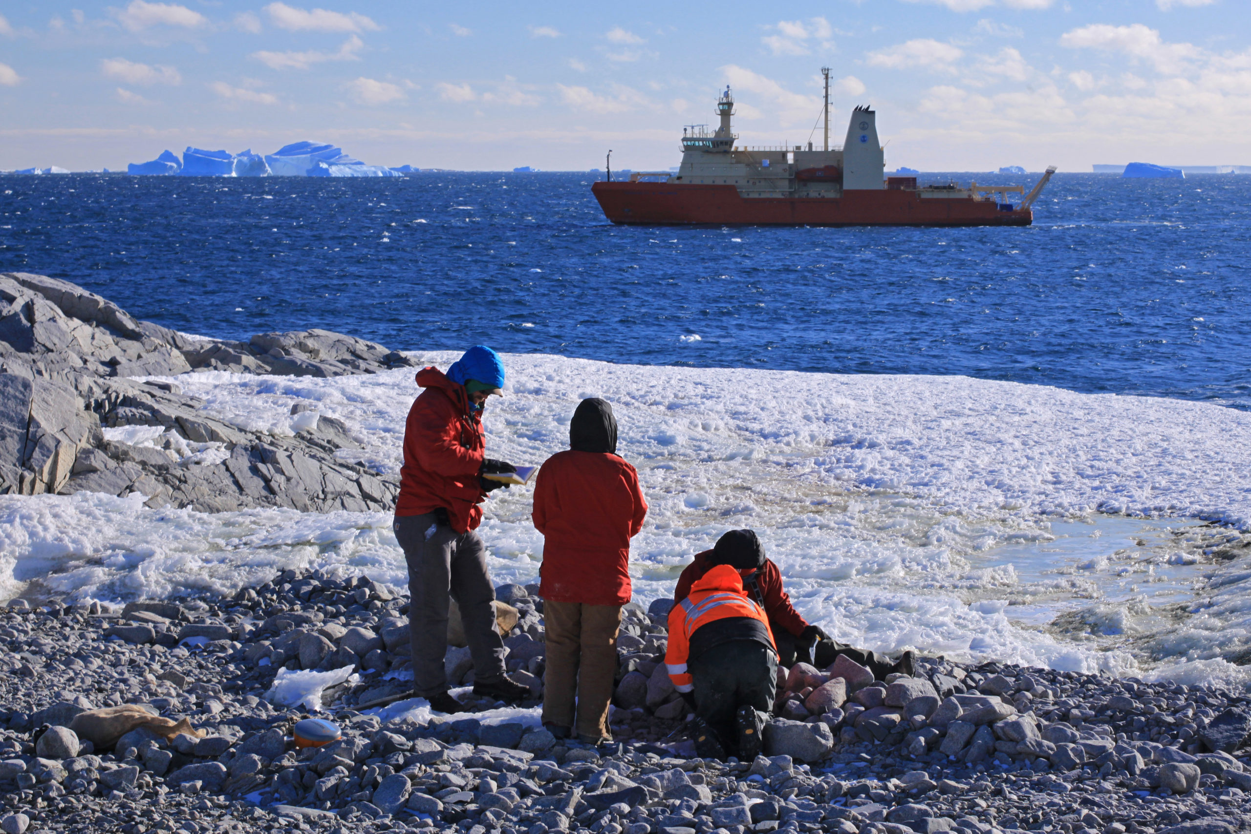 A group of people standing next to a body of water