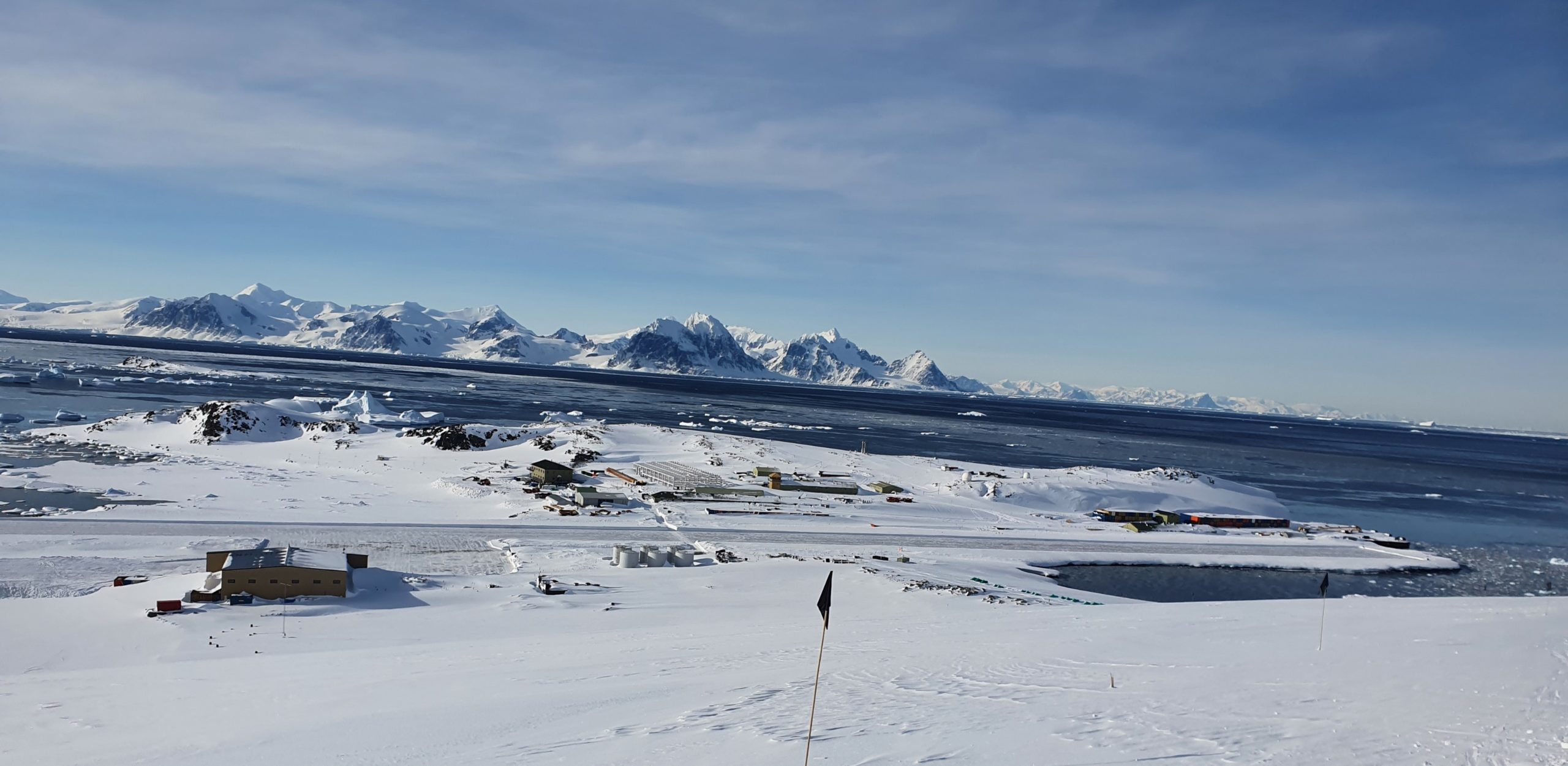 Rothera research station in Antarctica view from the west ramp showing a flag in foregrand and runway in background