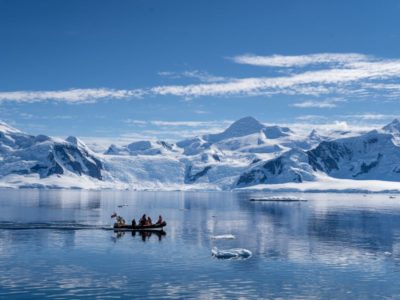 A body of water with a mountain in the snow