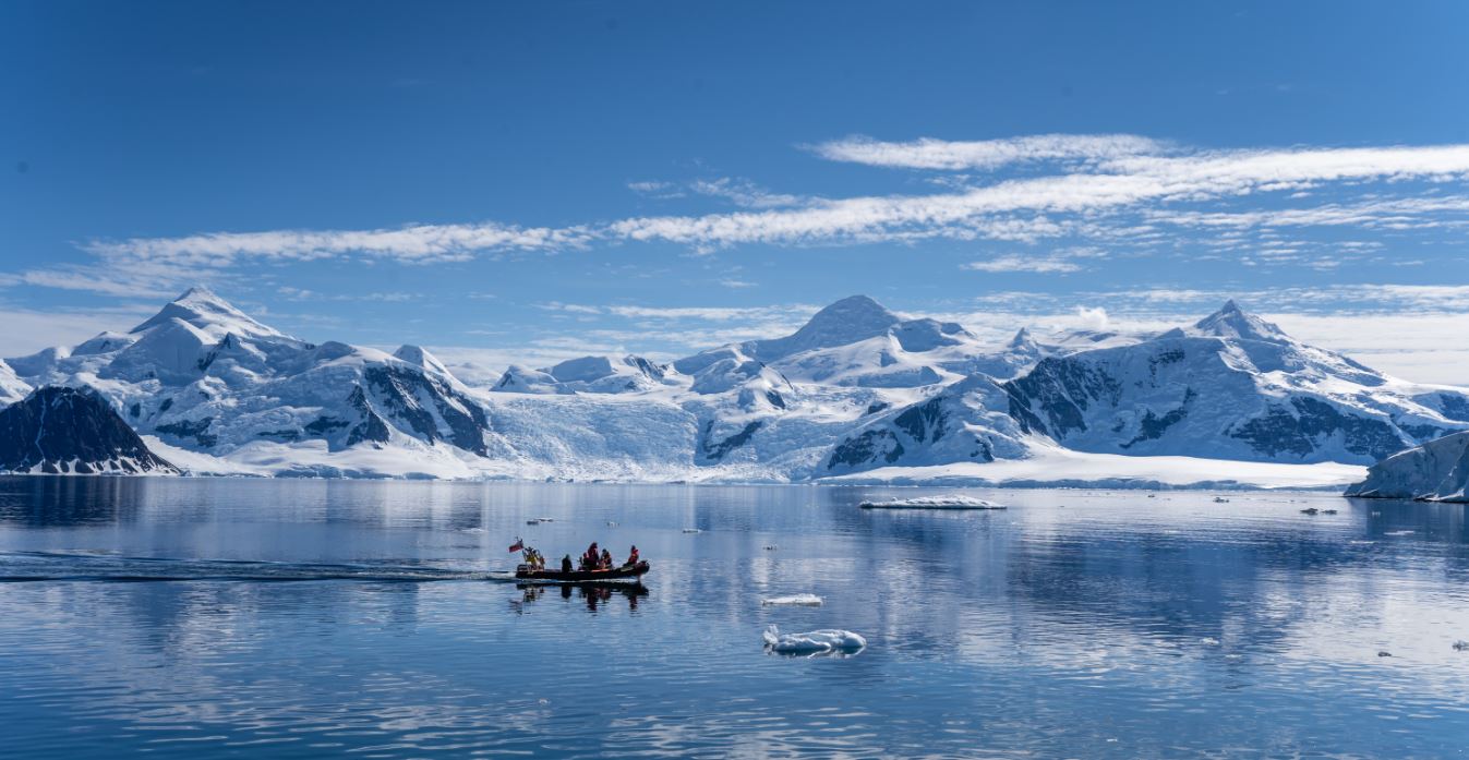 A body of water with a mountain in the snow