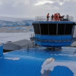 Construction team standing on top of operations tower of a new building in Antarctica