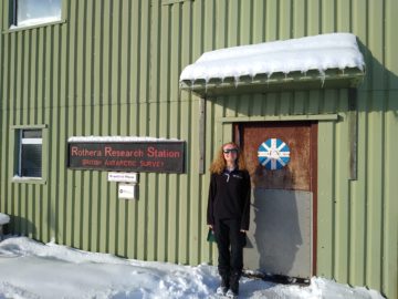 A person standing in front of a building in the snow
