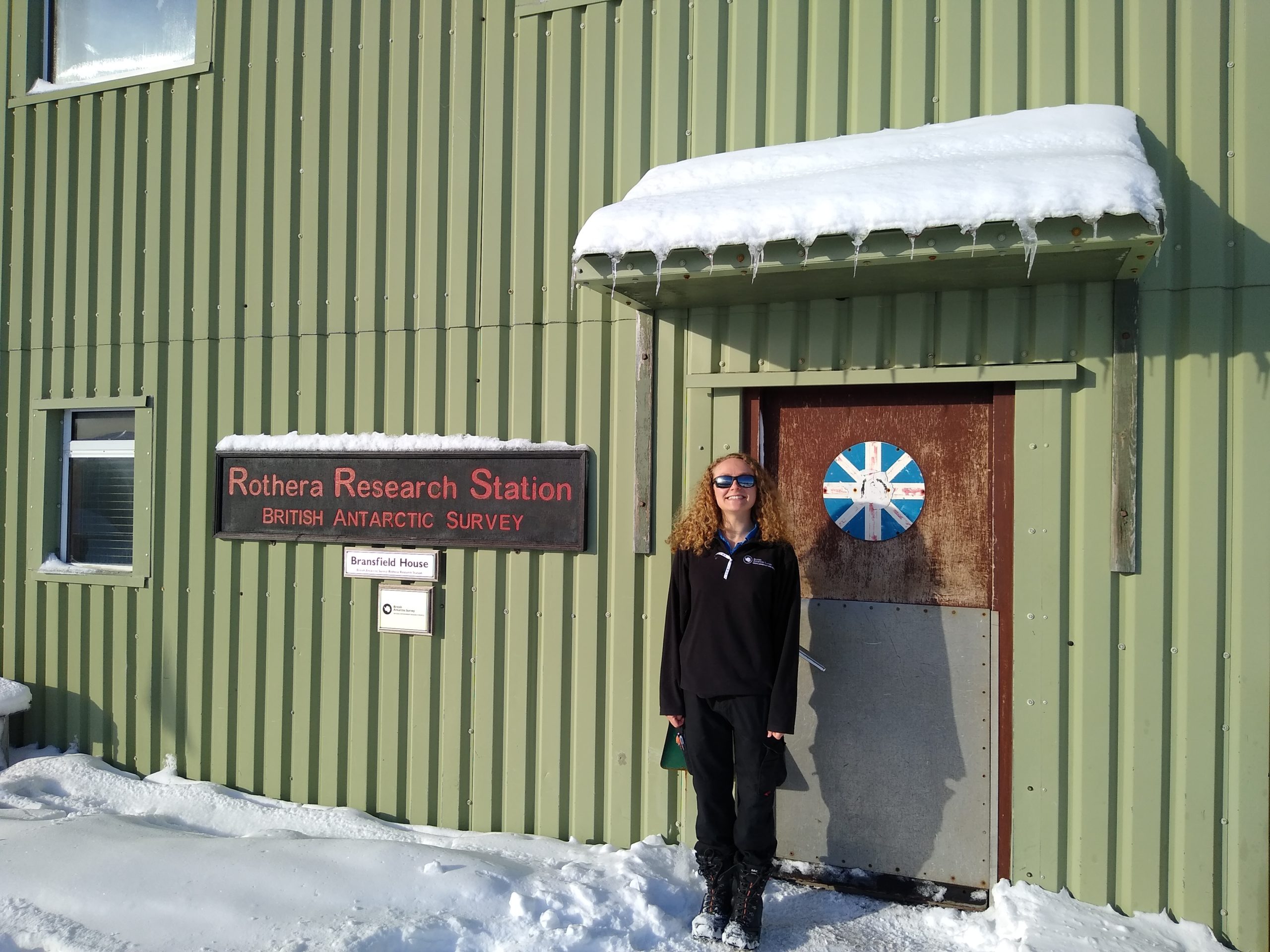 A person standing in front of a building in the snow