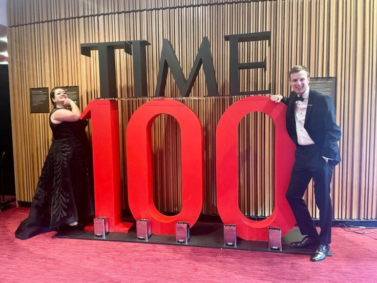 Britney and Pete lean either side of a huge statue of the words TIME100. Britney wears a black ballgown with swirling lead patterns, and Pete is in black tie, jacket open.