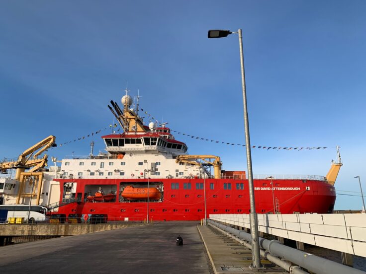 A large red ship against a blue sky