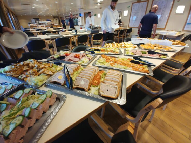 A group of people sitting at a table full of food