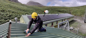 A person sitting on a bench with a mountain in the background