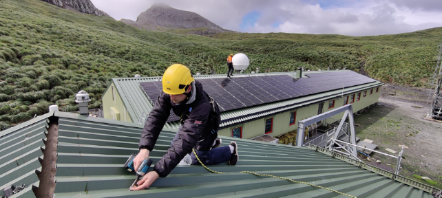 A person sitting on a bench with a mountain in the background