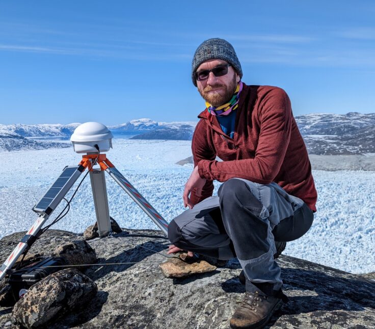 A man sitting next to a body of water