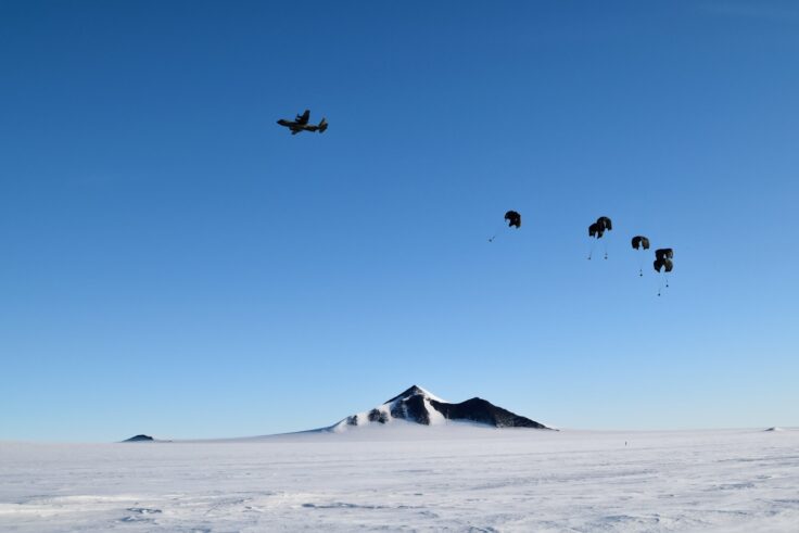 A group of people flying kites in the snow