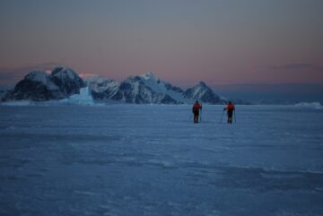 A group of people standing on top of a snow covered mountain