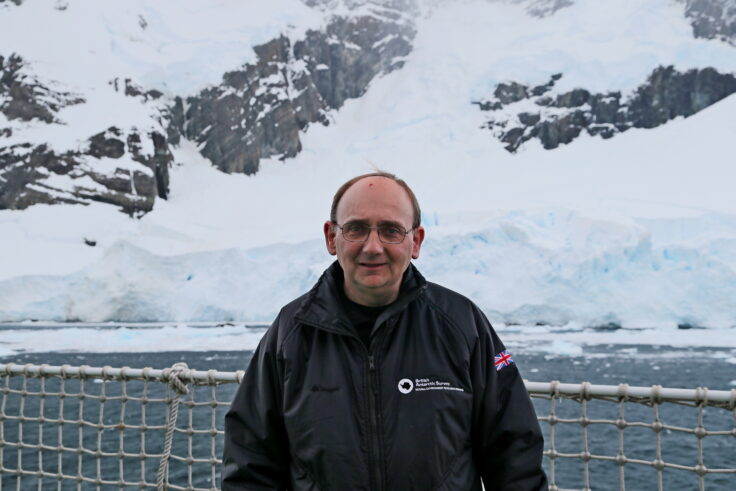 A man standing in front of a snowy slope