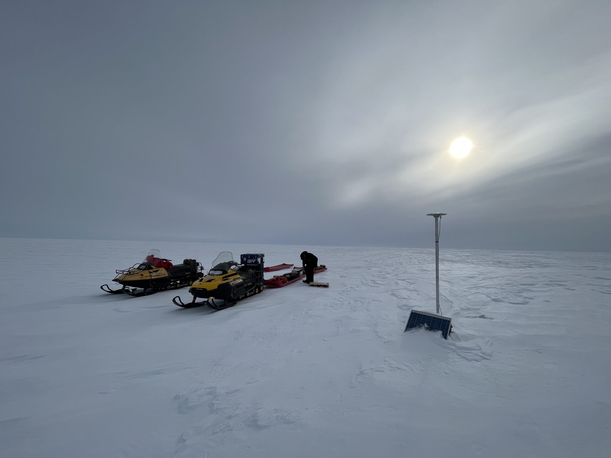 A group of people riding skis across snow covered ground