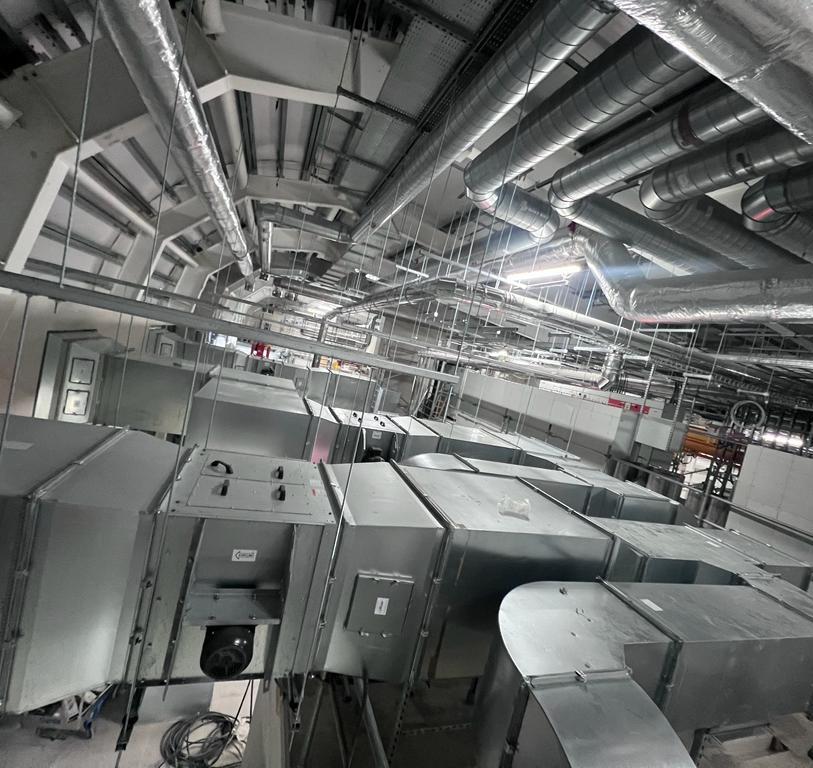 Internal metal pipeworks inside a large warehouse building