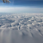 A group of clouds in the sky over a snow covered slope