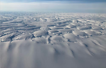 A group of clouds in the sky over a snow covered slope