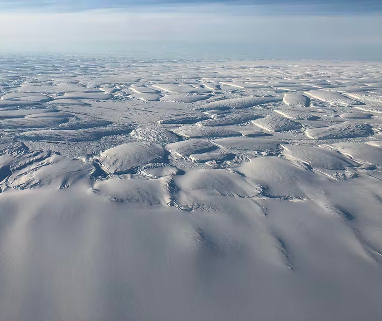 A group of clouds in the sky over a snow covered slope