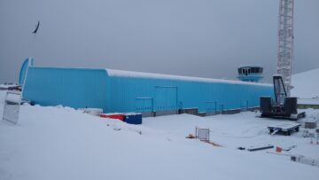 A blue building that is covered in snow