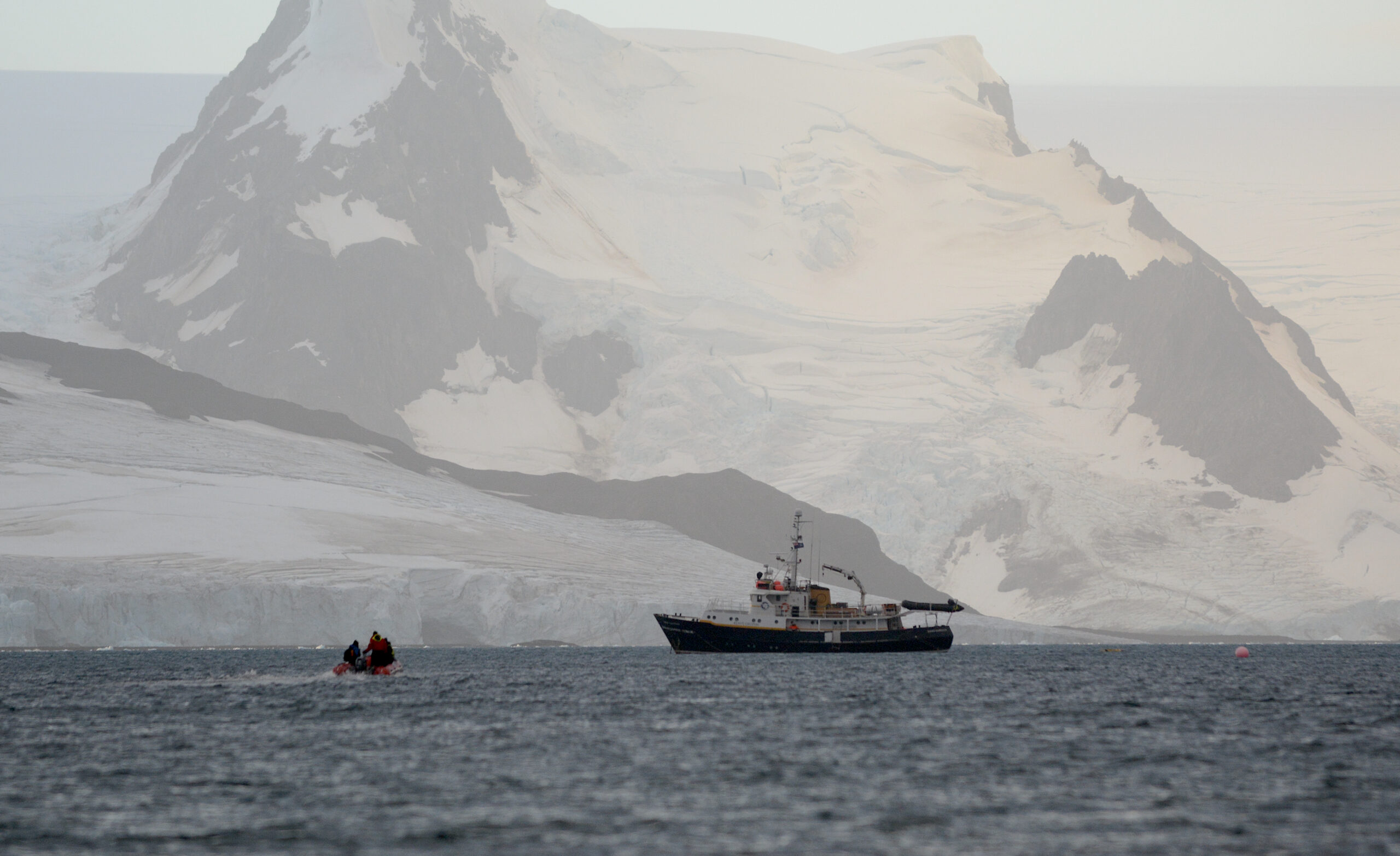 A boat in front if an iceberg