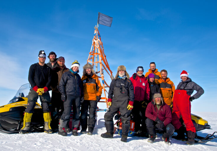 A group of people standing on top of a snow covered slope