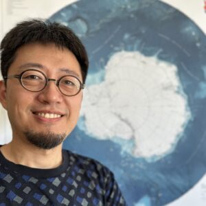 A man wearing glasses and smiling at the camera