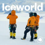 A group of people standing on top of a snow covered slope