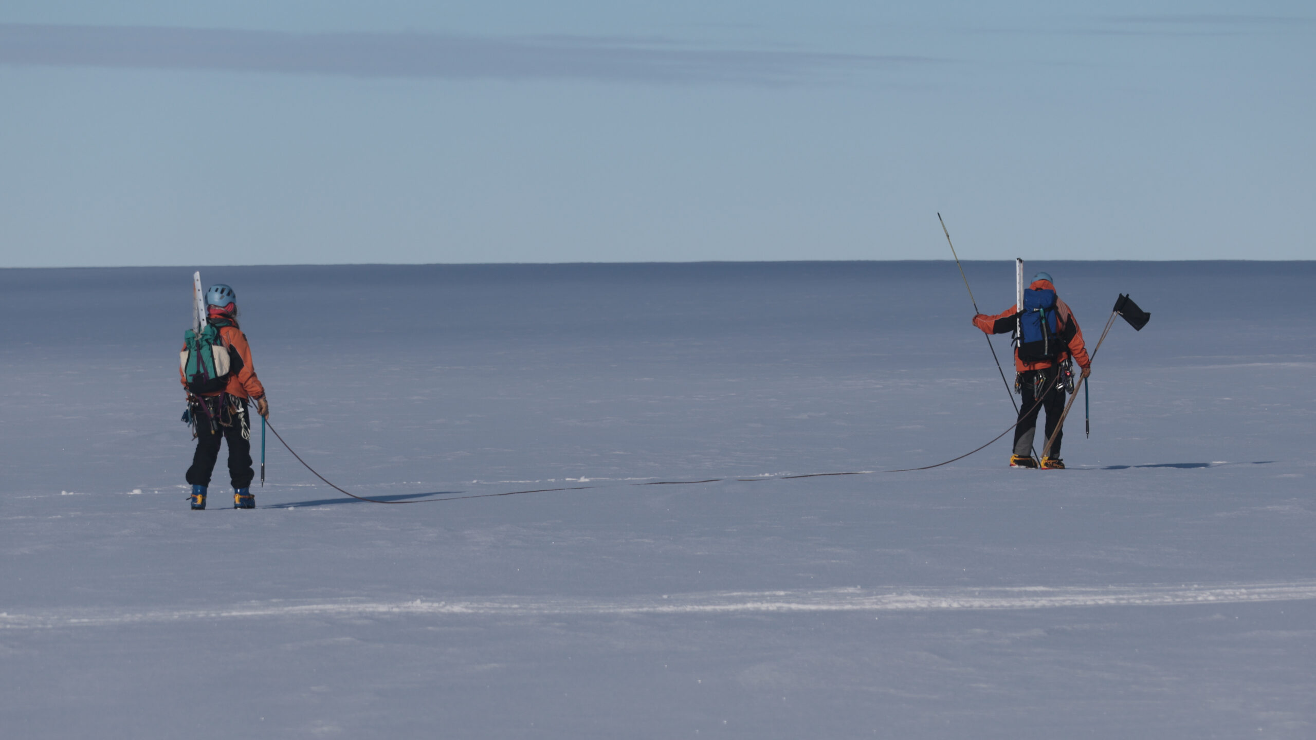 Two people walking across ice