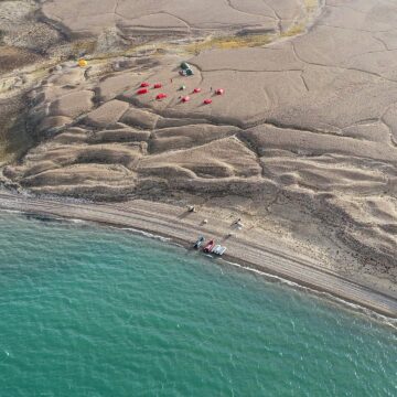 A group of people on a beach near a body of water