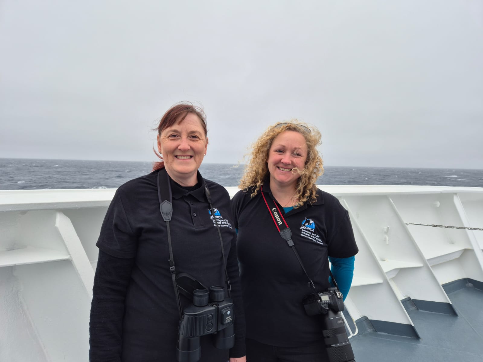 A man and a woman standing in front of a body of water